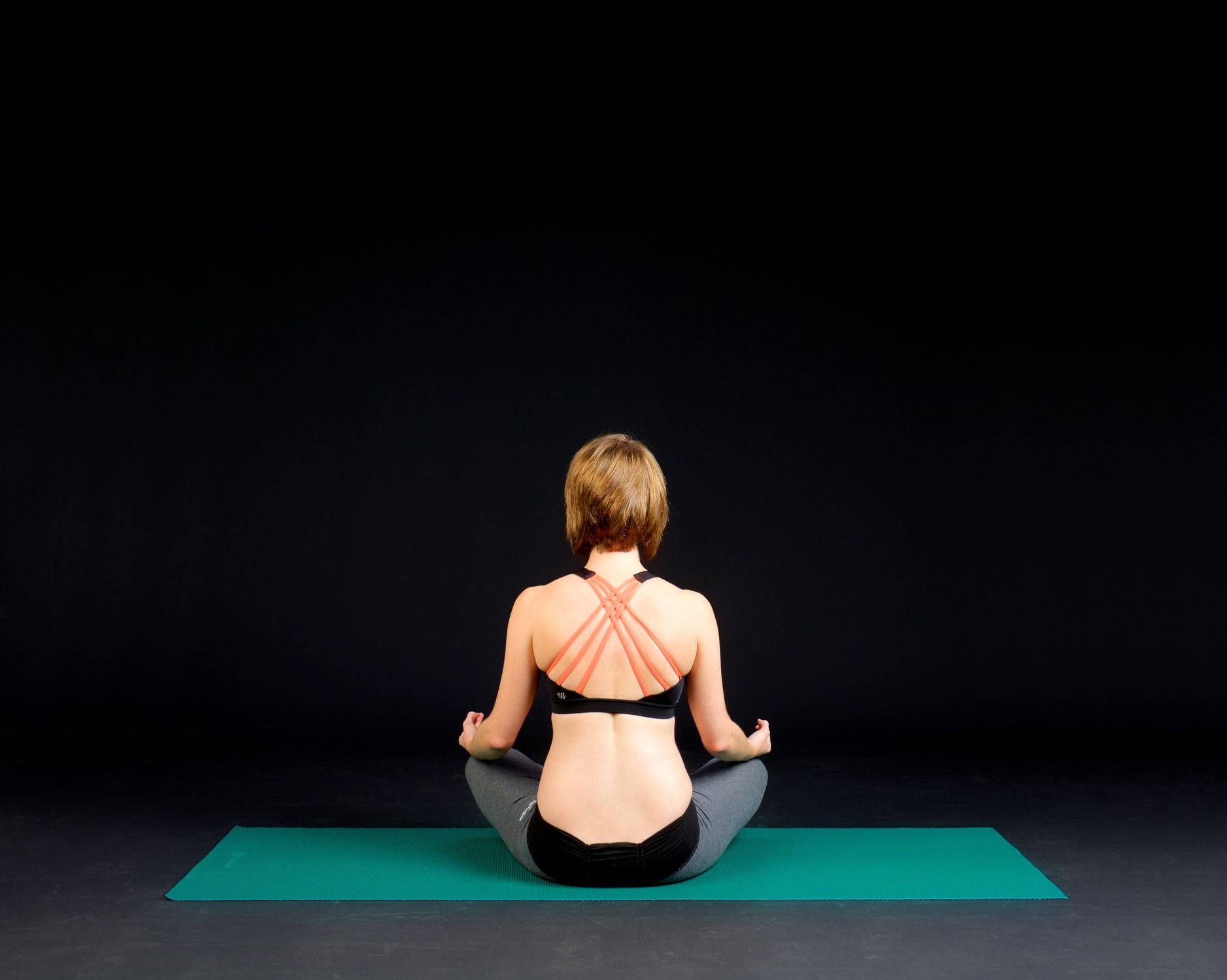 Mulher praticando yoga em um ambiente tranquilo, focada no equilíbrio e bem-estar mental