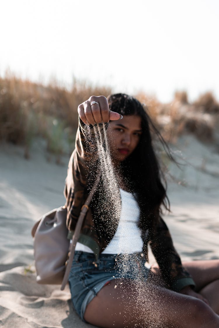 Shallow Focus Photography Of Woman Sitting On Sand