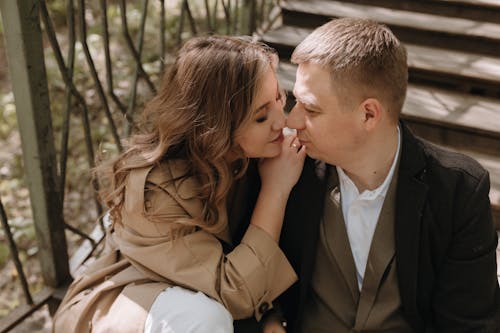 A couple is sitting on a wooden staircase