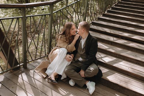 A couple sitting on the stairs in the woods