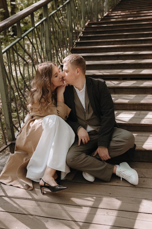 A couple sitting on the stairs in the woods