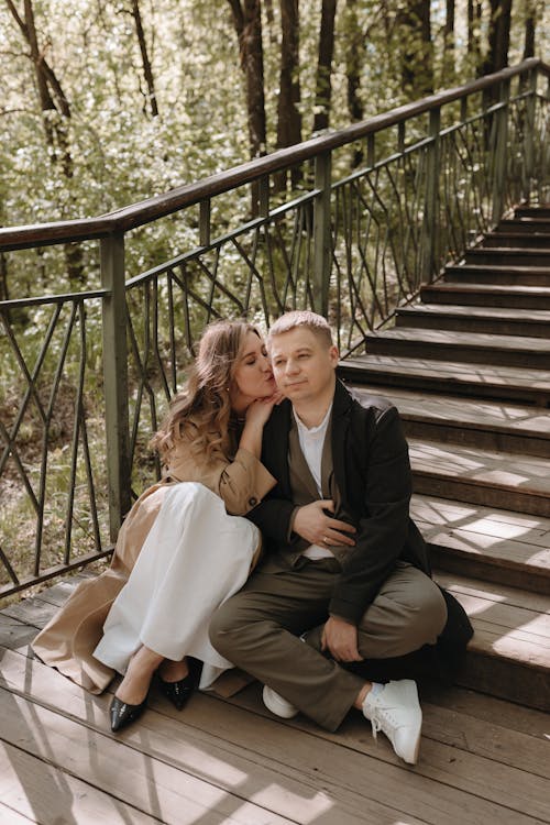 A couple sitting on the stairs in the woods