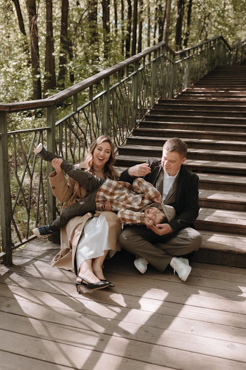 A family sitting on the stairs in the woods