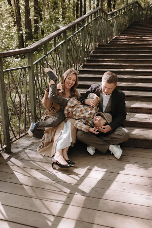 A family sitting on the stairs in the woods