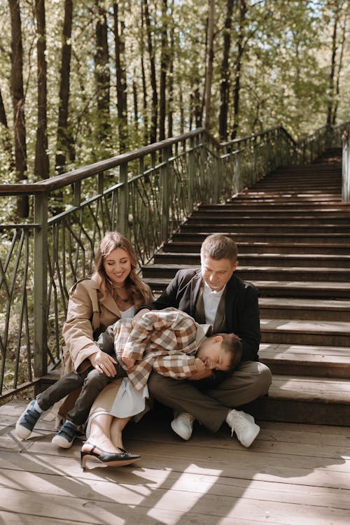 A family sitting on the stairs in the woods