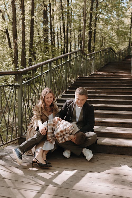 A family sitting on the stairs in the woods