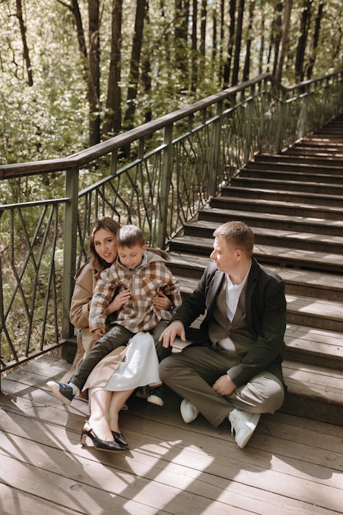 A family sitting on the stairs in the woods