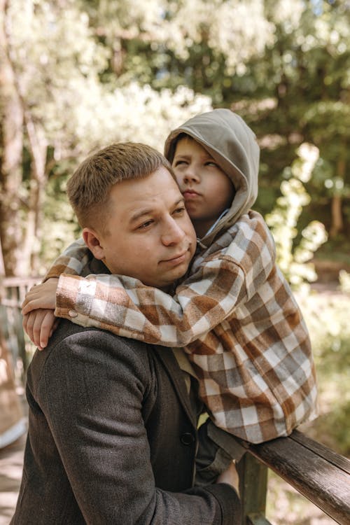 A man hugging a child on a bridge