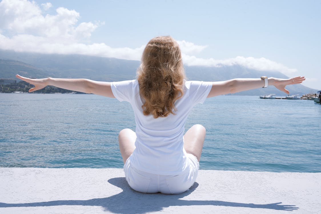 Photo of Woman Sitting Near Body of Water