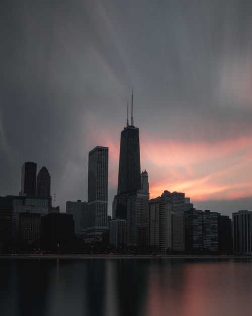 Free Dramatic dusk view of Chicago's skyline reflecting on calm lake waters. Stock Photo
