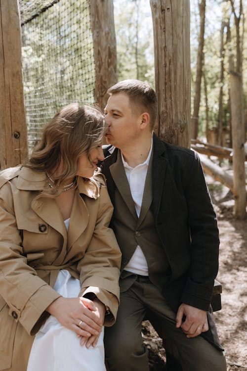 A couple sitting in the woods during their engagement session