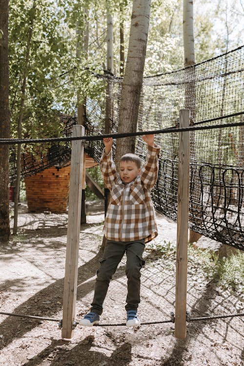 A boy is hanging on a rope in a tree house