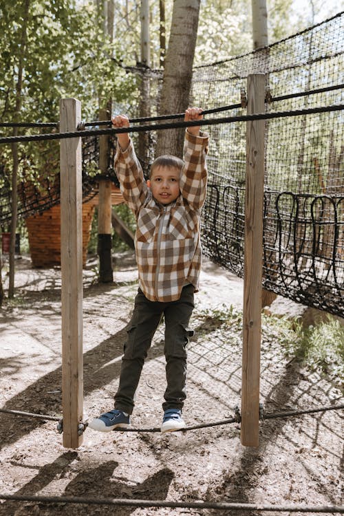 A boy standing on a rope in a tree house