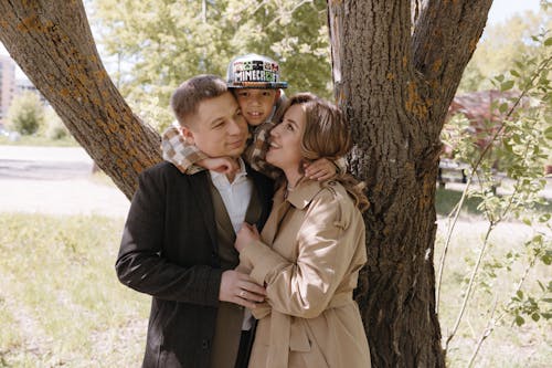 A man and woman hugging and posing for a photo in front of a tree