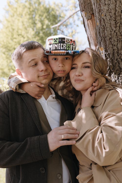 A family poses for a photo in front of a tree