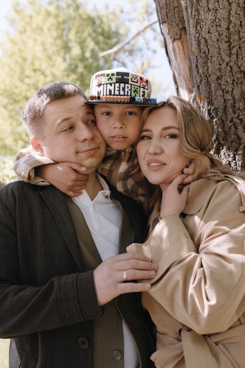 A man and woman are posing for a photo with their son