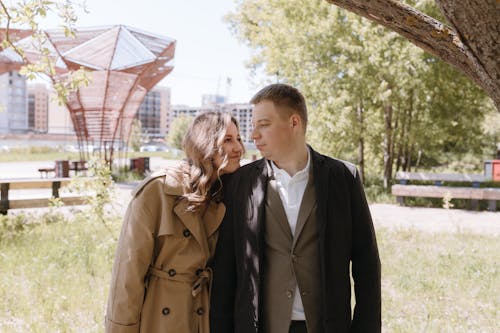 A couple standing in front of a tree in a park