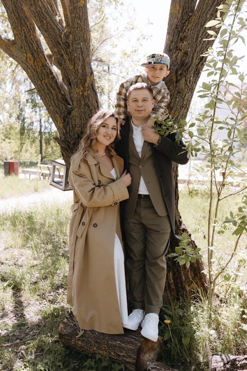 A man and woman are standing in front of a tree