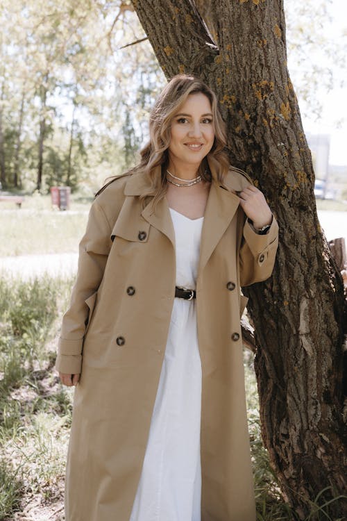 A woman in a trench coat posing for a photo