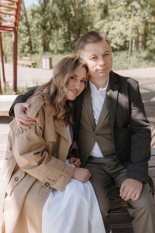 A man and woman sitting on a bench in the park