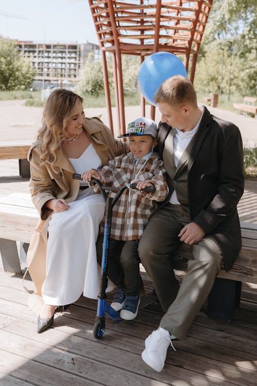 A family sitting on a bench with a boy in a wheelchair