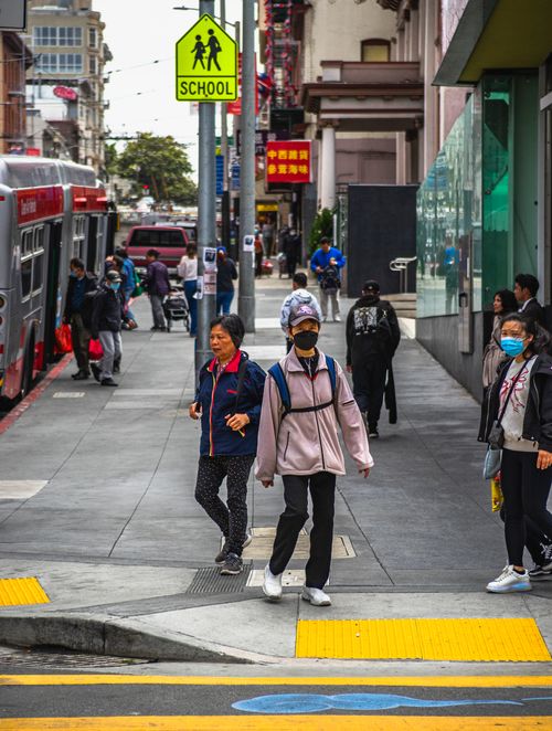 Free Lively city street featuring pedestrians and buses in an urban environment on a cloudy day. Stock Photo