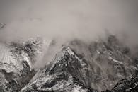 白雪皑皑的尼泊尔山峰被云层吞没，营造出阴沉的冬日景象