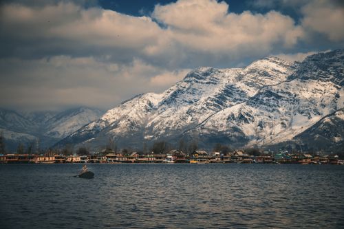Free Beautiful snowy mountains overlooking Dal Lake in Srinagar during winter, capturing serene urban and natural beauty. Stock Photo