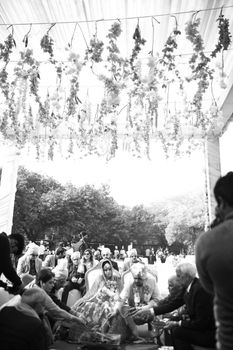 A black and white photo depicting a wedding ceremony with floral decorations outdoors.