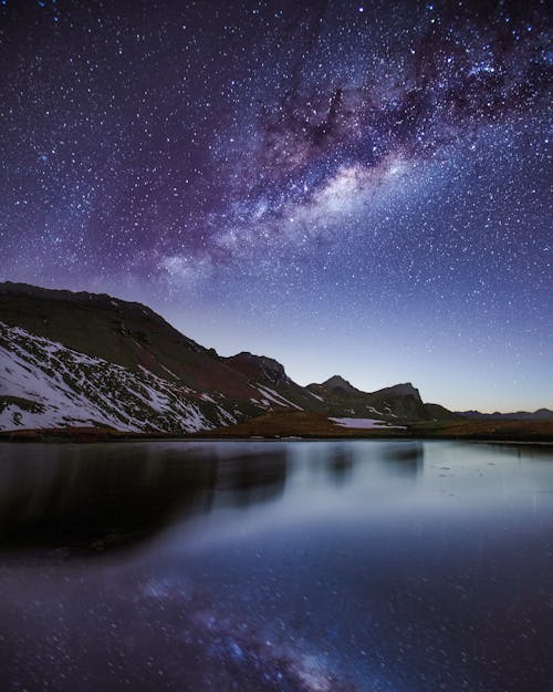 Lake Near A Mountain With Snow Under Night Sky