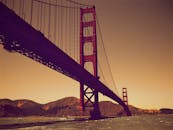 日落时，金门大桥在旧金山湾上空展现出标志性设计的戏剧性景色