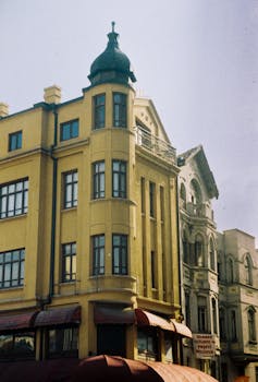 A picturesque view of a historic yellow building in a Turkish urban setting, under a clear sky.