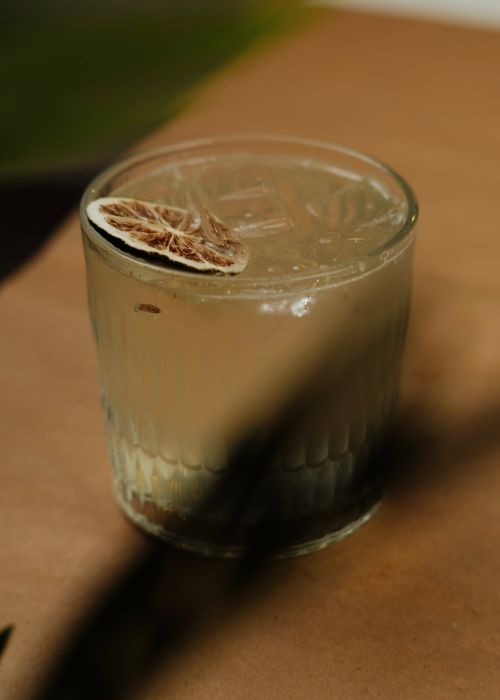 Free A refreshing cocktail in a glass with a dried citrus garnish on a wooden table. Stock Photo