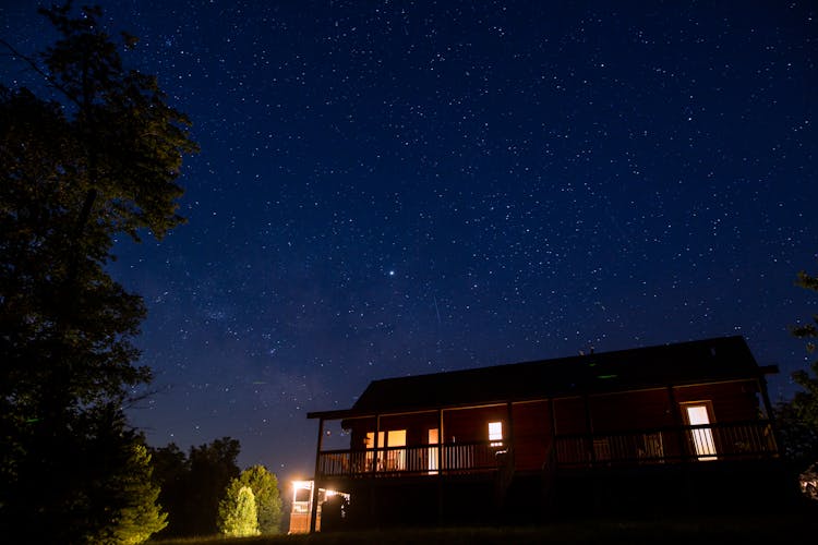 Photo Of Lighted House Under Starry Night Sky