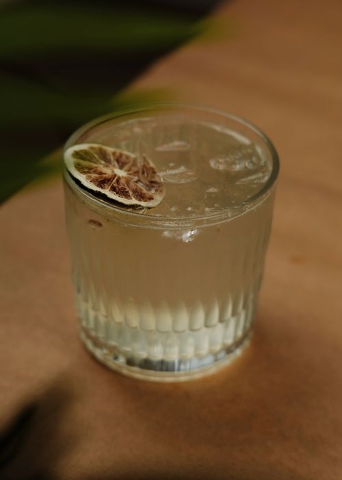 Free Chilled cocktail with ice and lime slice in glass, perfect for summer refreshment. Stock Photo