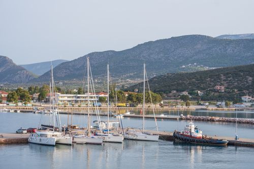 Free Scenic view of a marina with moored yachts against a mountain backdrop on a sunny day. Stock Photo