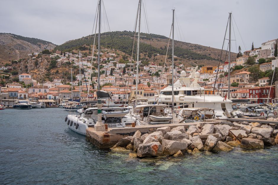 Ultimate Semi-Private Sailing Cruise to Iconic Bays (Shore-Ex Top Choice) Review: Your Ultimate Rhodes Sailing Adventure Review 2026 - Scenic view of a marina with yachts in a Mediterranean coastal town, surrounded by hills and vibrant architecture.