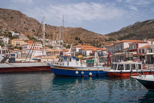 Free Scenic view of a Greek coastal town with colorful fishing boats docked at the marina. Stock Photo