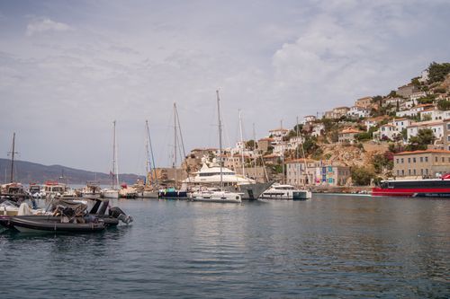 Free A serene harbor with yachts and a picturesque hillside town under a cloudy sky, perfect for travel inspiration. Stock Photo
