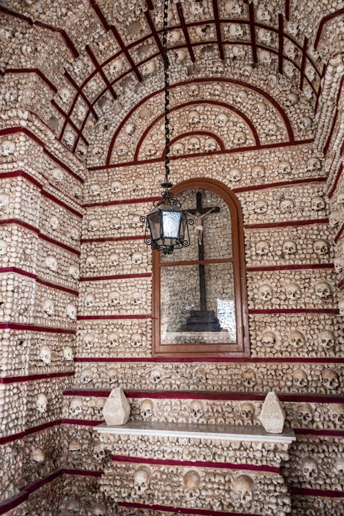 Free Eerie interior of Capela dos Ossos in Faro, Portugal, displaying bones and cross. Stock Photo