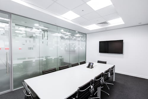 Rectangular White Table With Rolling Chairs Inside Room