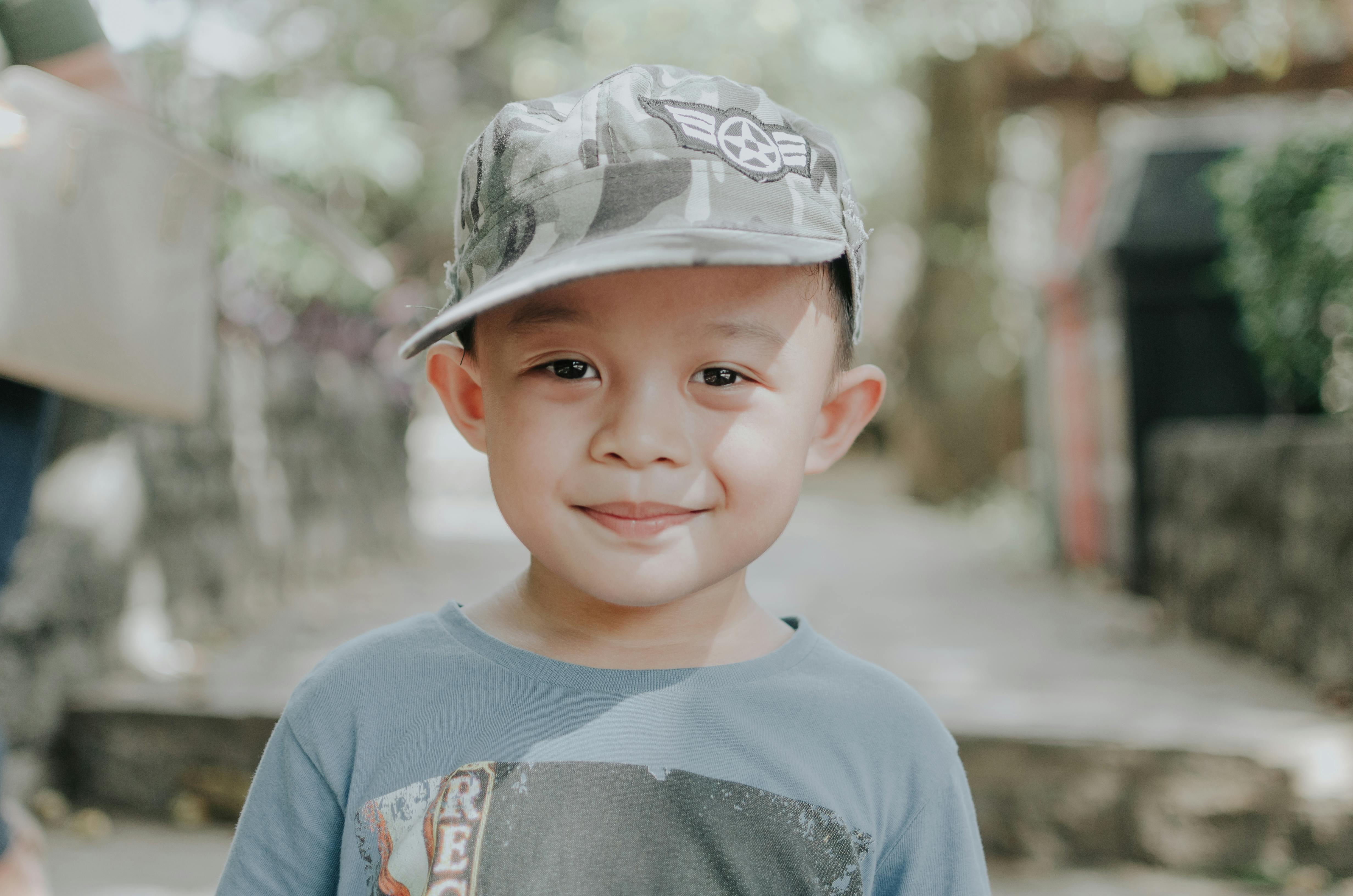 Selective Focus Portrait Photo of Smiling Boy in Camouflage Cap · Free ...