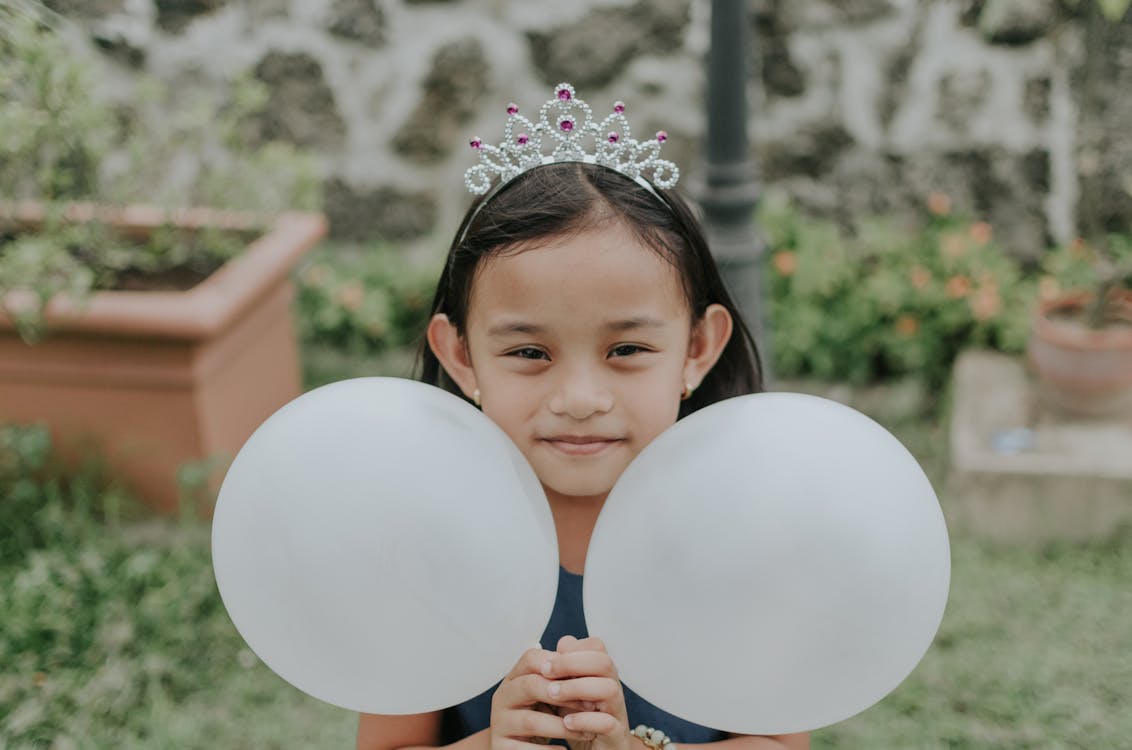 Girl Wearing A Crown Holding Two White Balloons
