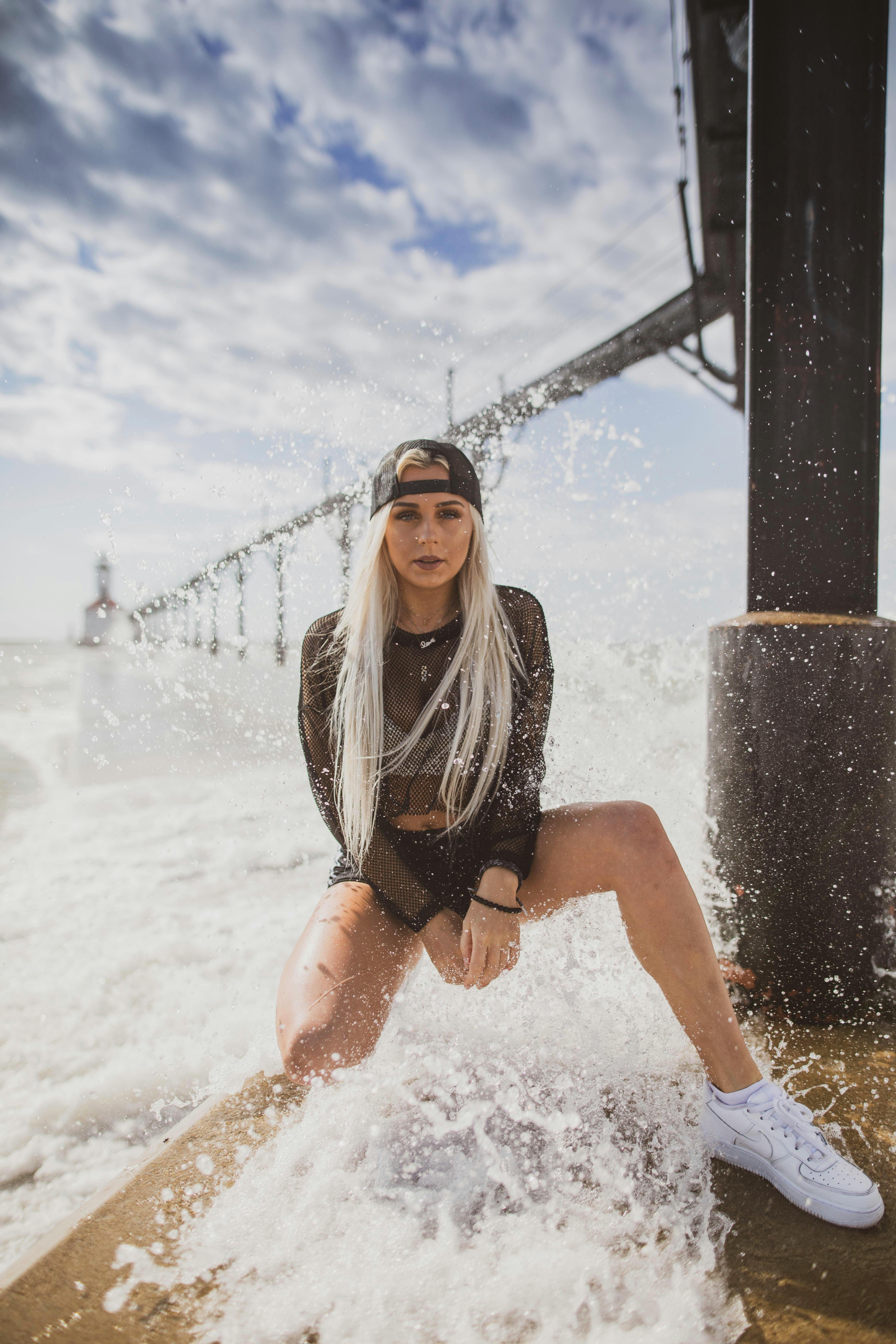 一位时尚女士在波涛汹涌的码头边摆姿势