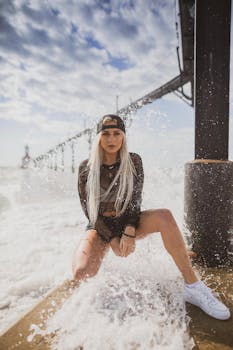 一位时尚女士在波涛汹涌的码头边摆姿势