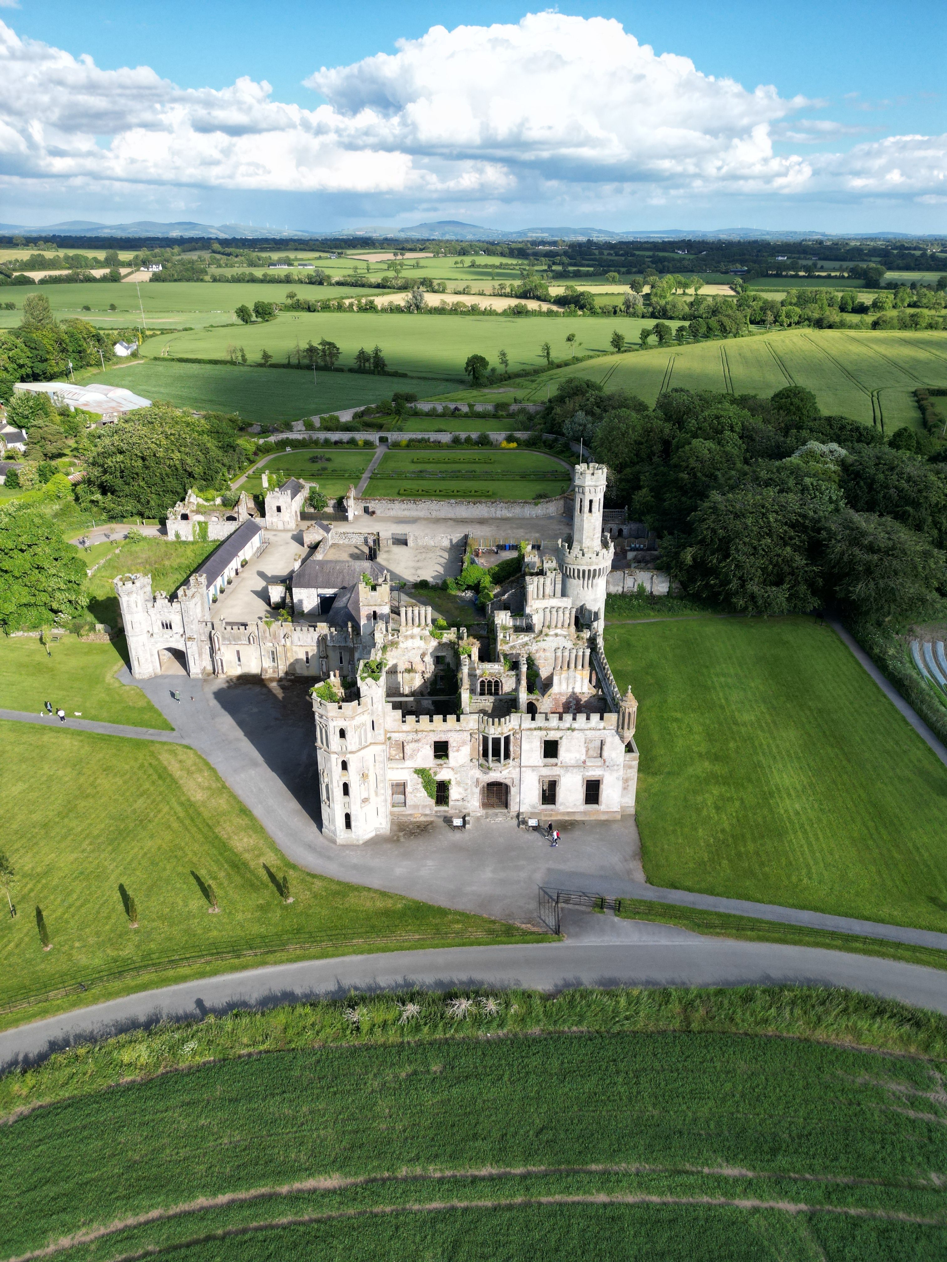 Drone shot of Ducketts Grove, a historic Irish castle surrounded by lush countryside.