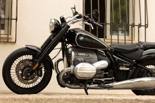 Free A stylish black motorcycle with a classic design parked in front of a building. Stock Photo