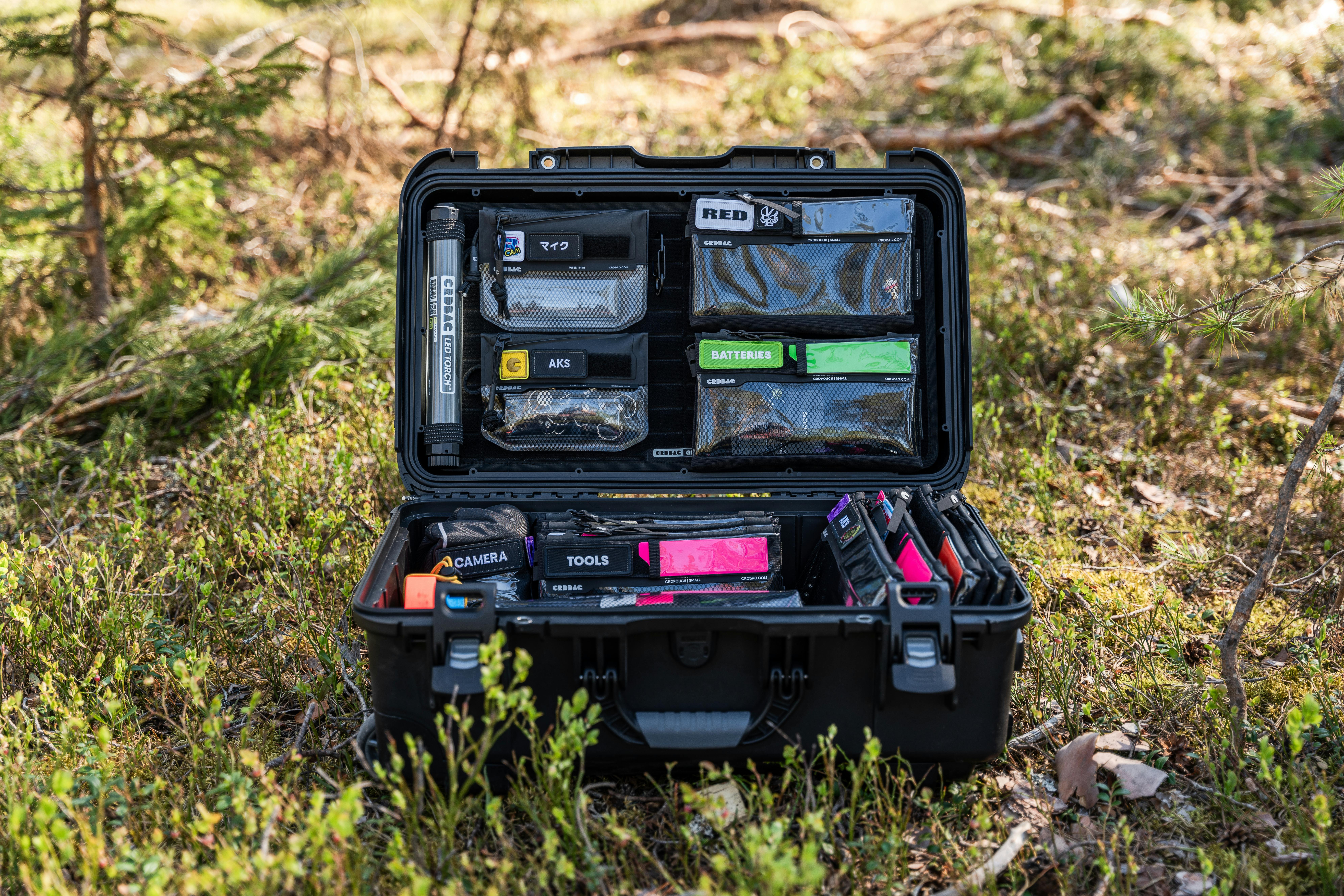 Open hard case filled with camera gear and tools in a forest setting, Sundsvall, Sweden.