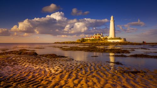 Free Beautiful view of St. Mary's Lighthouse reflecting on the shore during sunset in Whitley Bay, England. Stock Photo