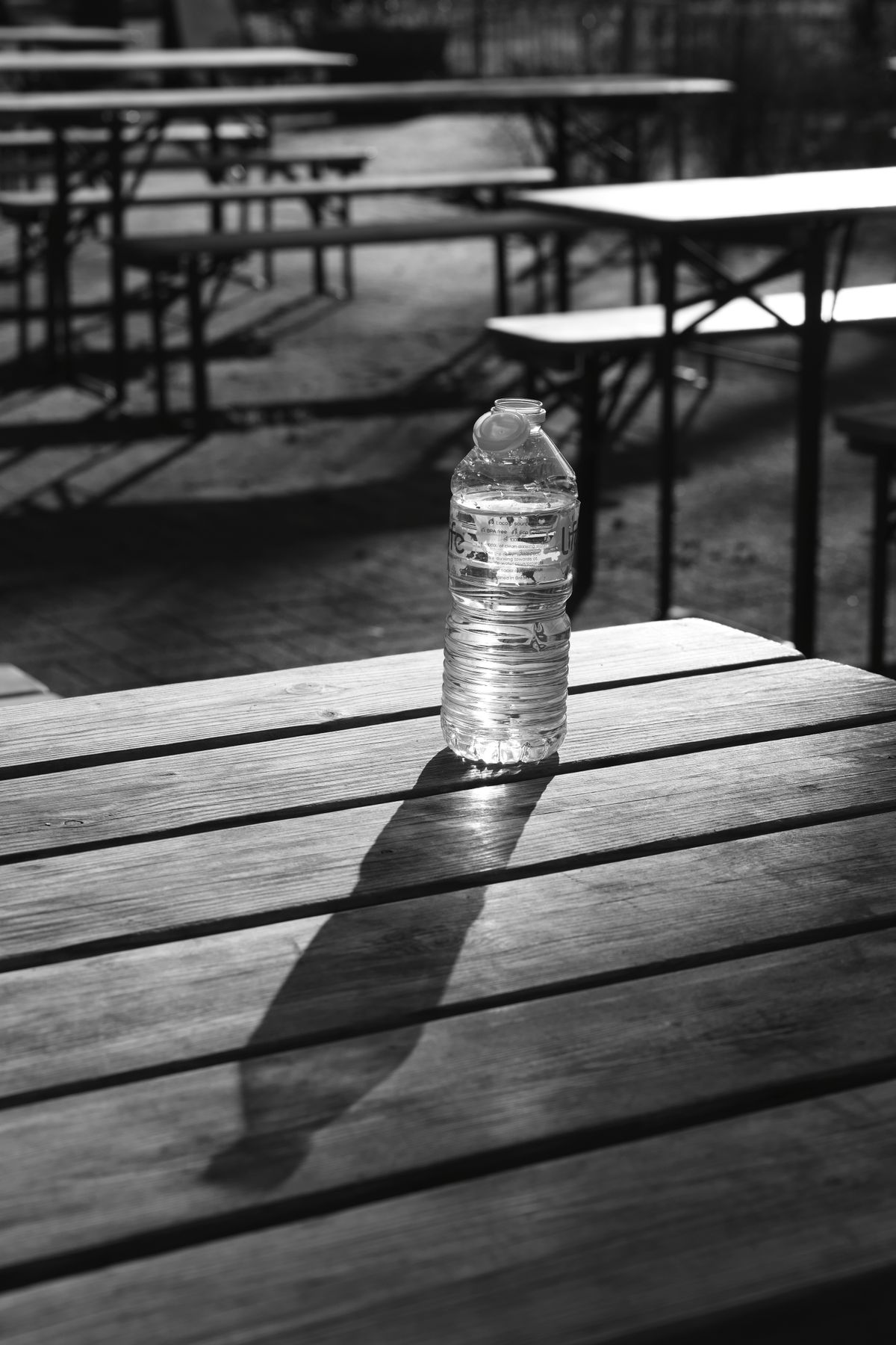 Fotografija boce s dugom sjenom koja stvara snažnu dijagonalu i vodi pogled kroz kadar.